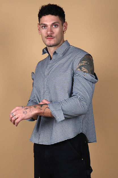 The front button down low crop shirt with a shirt collar and front button closure might seem like your run of the mill shirt. However the shirt can be styled partially sleeved or completely sleeveless with detachable sleeves that can be snapped on and off in parts or completely.  The monochrome check shirt is the perfect cropped moment that lets you style it in more ways than one. Go for the full sleeves, cold shoulder on either or both arms or completely sleeveless - the possibilities are endless.