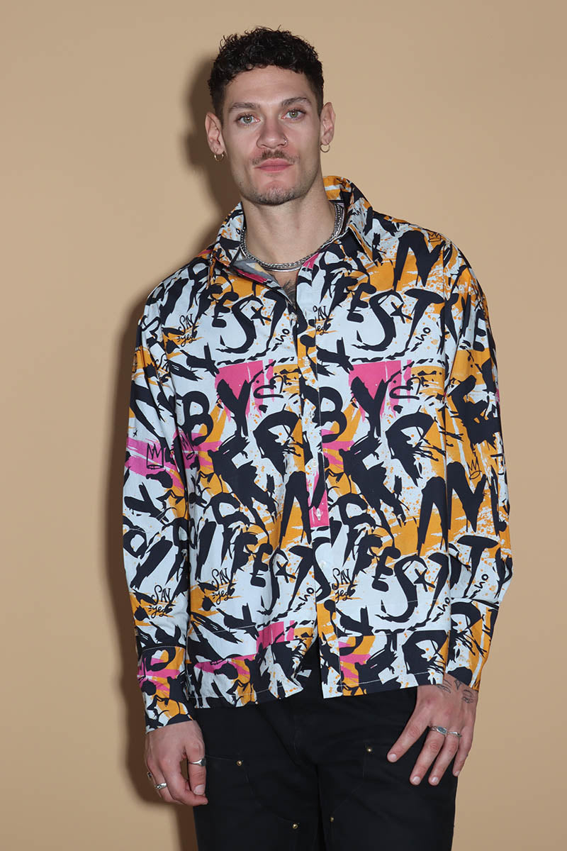 In an overall graffiti print, the oversize shirt keeps it fun in exuding a confident charm. Grunge vibe with a difference, the shirt has a shirt collar and front closure however it is the details that make it knot your average shirt. The shirt has a layered detail on the front and the back. The long sleeves come with an extra long cuff, that can be rolled up for a statement sleeve look or a sleeker cuffed up look.
