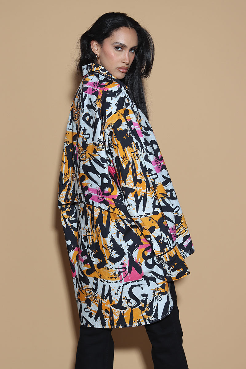 In an overall graffiti print, the oversize shirt keeps it fun in exuding a confident charm. Grunge vibe with a difference, the shirt has a shirt collar and front closure however it is the details that make it knot your average shirt. The shirt has a layered detail on the front and the back. The long sleeves come with an extra long cuff, that can be rolled up for a statement sleeve look or a sleeker cuffed up look.