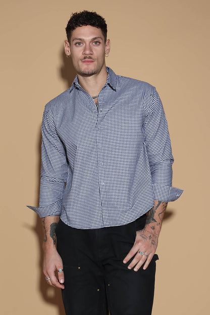 The front button down low crop shirt with a shirt collar and front button closure might seem like your run of the mill shirt. However the shirt can be styled partially sleeved or completely sleeveless with detachable sleeves that can be snapped on and off in parts or completely.  The monochrome check shirt is the perfect cropped moment that lets you style it in more ways than one. Go for the full sleeves, cold shoulder on either or both arms or completely sleeveless - the possibilities are endless.