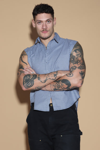 The front button down low crop shirt with a shirt collar and front button closure might seem like your run of the mill shirt. However the shirt can be styled partially sleeved or completely sleeveless with detachable sleeves that can be snapped on and off in parts or completely.  The monochrome check shirt is the perfect cropped moment that lets you style it in more ways than one. Go for the full sleeves, cold shoulder on either or both arms or completely sleeveless - the possibilities are endless.