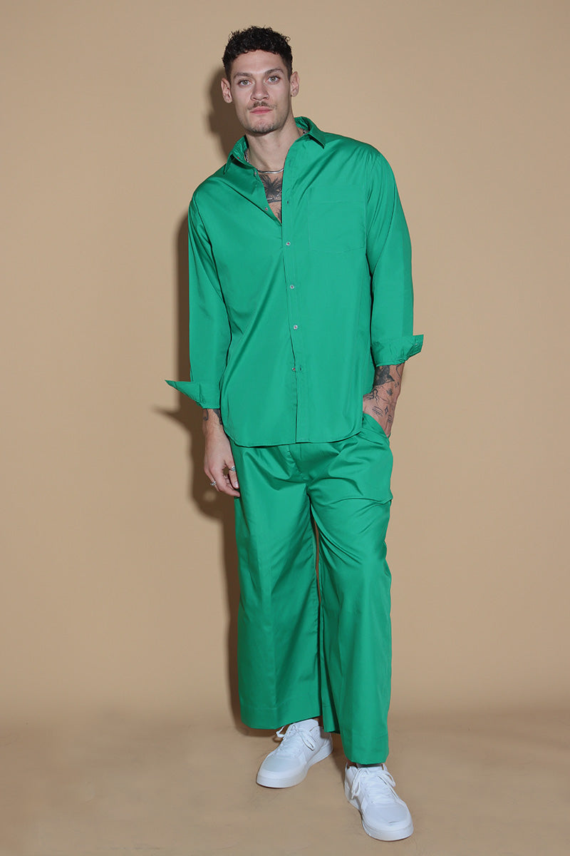 In Emerald green jewel tone, the twin co-ord set unisex, menswear and womenswear with an oversized shirt and wide leg pants with a drawstring and elasticated waist are your perfect go to for the season. They're an oversized fit, looser and baggier in their styling, and designed to be worn in a very casual manner. the separates can be styled together for a statement look or separately.