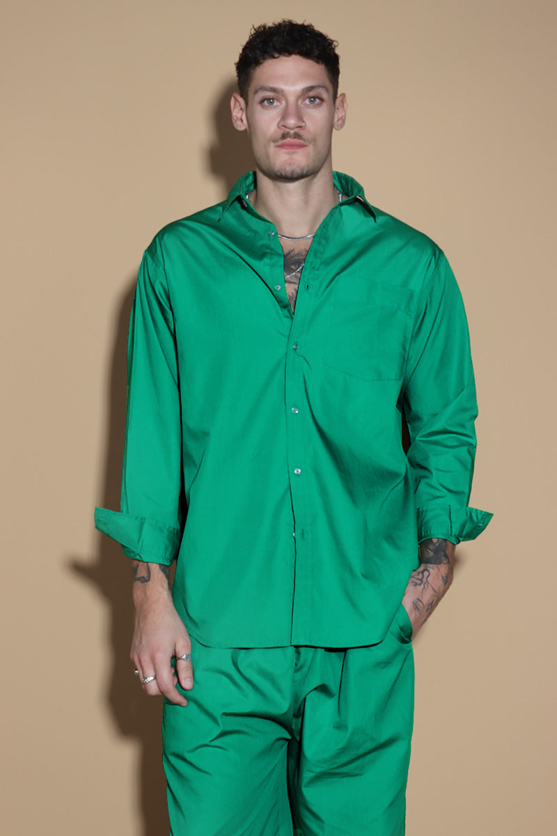 In Emerald green jewel tone, the twin co-ord set unisex, menswear and womenswear with an oversized shirt and wide leg pants with a drawstring and elasticated waist are your perfect go to for the season. They're an oversized fit, looser and baggier in their styling, and designed to be worn in a very casual manner. the separates can be styled together for a statement look or separately.