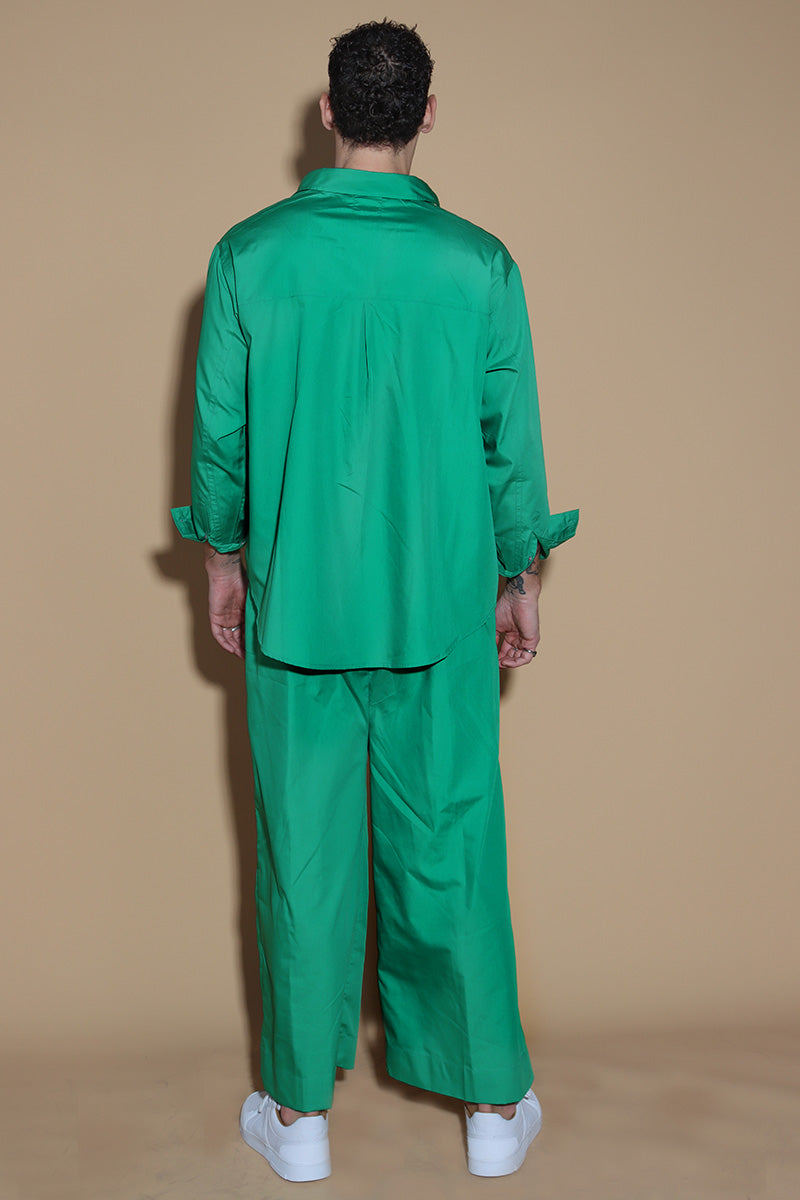 In Emerald green jewel tone, the twin co-ord set unisex, menswear and womenswear with an oversized shirt and wide leg pants with a drawstring and elasticated waist are your perfect go to for the season. They're an oversized fit, looser and baggier in their styling, and designed to be worn in a very casual manner. the separates can be styled together for a statement look or separately.