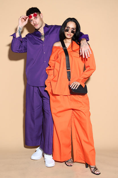 Orange set with a button up shirt with contrasting button stitches and wide leg pants with elastic that can be adjusted accordingly. The Pieces are designed to be oversized and styled casually.  Along with an easy and relaxed fit shirt, the separates can be styled together for a statement.