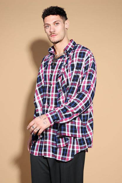 An easy shirt that sashays with your every move. The Sway Drape shirt in Cotton has an overall check in tones of purples and pinks. The shirt has a shirt collar and front button closure, with a double layer front with button and button-holes to create optional drape effect.