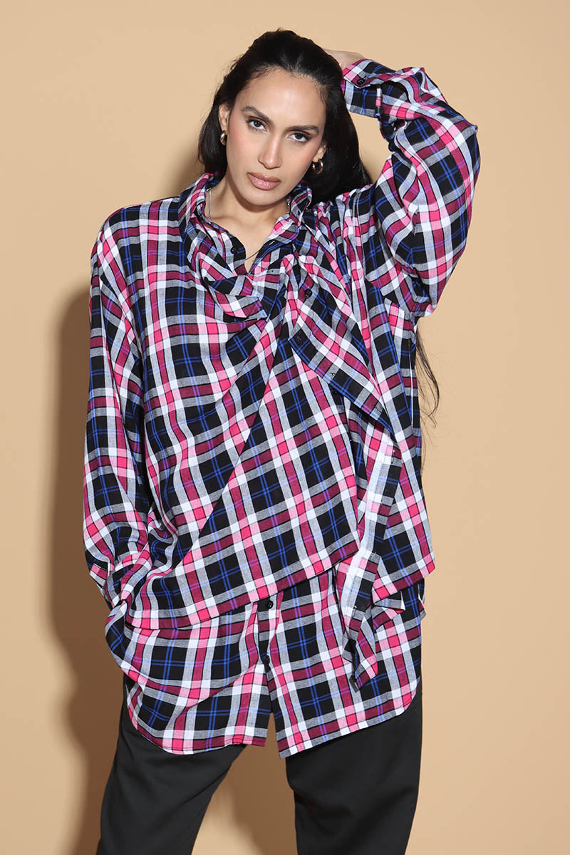 An easy shirt that sashays with your every move. The Sway Drape shirt in Cotton has an overall check in tones of purples and pinks. The shirt has a shirt collar and front button closure, with a double layer front with button and button-holes to create optional drape effect.