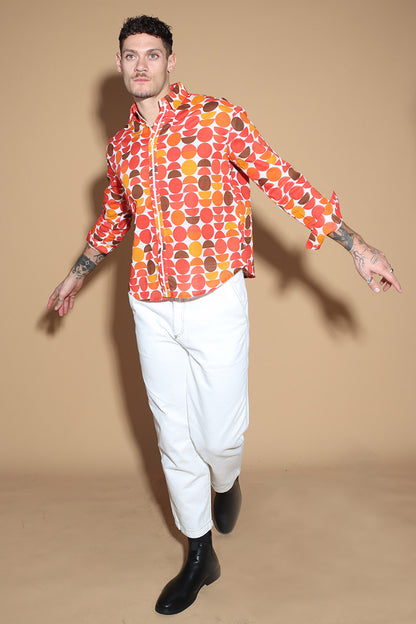 Exude a fun retro vibe of the sixties and seventies that makes for a fun look in this shirt. In warm tones of reds, oranges and yellows, the overall circle print shirt has a shirt collar and front button closure with full sleeves. Trimmed and complimented with white details that finish off the look giving it just the polished look needed. Style this fun retro shirt with white pants or denims or white shorts.