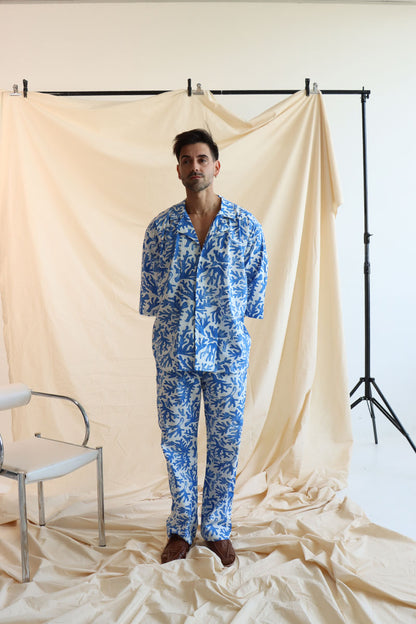 a coral print linen set with a button-down shirt and 3/4 sleeves, paired with matching relaxed pants with an elastic waistband and drawstring.