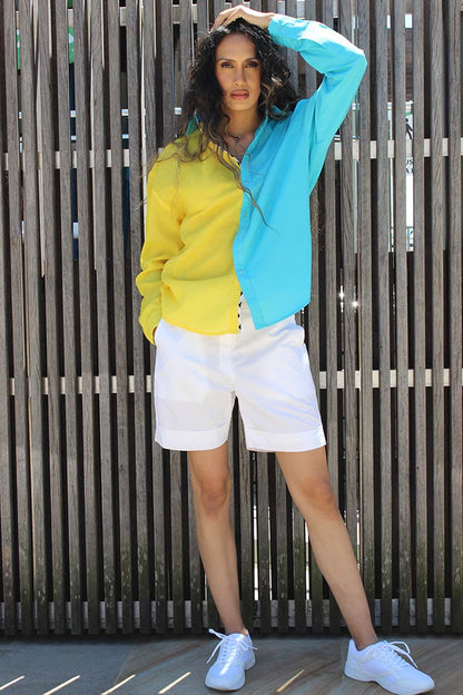 The easy summer shirt that is striking as it is bold in its approach. The oversized 90s referenced Cyrus Shirt is a two toned shirt in Cotton with a shirt collar and cuffed sleeves. In bright tones perfect for a sunny side day, the shirt has black and white trims that give it an extra edge and detail that you might not find somewhere else. Devil surely is in the details. A front button down and style it with Bliss shorts or pants for an easy statement look.
