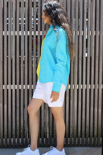 The easy summer shirt that is striking as it is bold in its approach. The oversized 90s referenced Cyrus Shirt is a two toned shirt in Cotton with a shirt collar and cuffed sleeves. In bright tones perfect for a sunny side day, the shirt has black and white trims that give it an extra edge and detail that you might not find somewhere else. Devil surely is in the details. A front button down and style it with Bliss shorts or pants for an easy statement look.